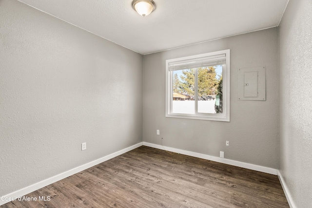 unfurnished room featuring hardwood / wood-style floors and electric panel