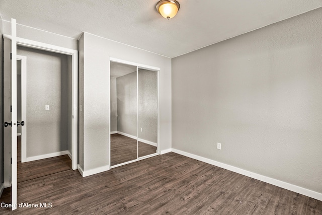 unfurnished bedroom featuring a closet and dark hardwood / wood-style floors