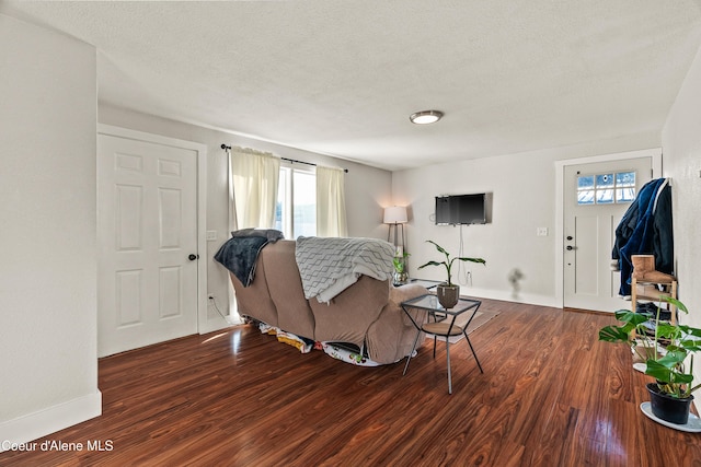 living room with dark hardwood / wood-style floors and a textured ceiling