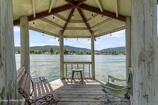 view of dock featuring a gazebo and a water and mountain view