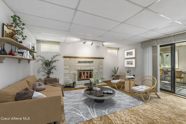 living room featuring a drop ceiling, a fireplace, and rail lighting