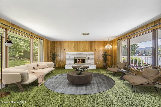 carpeted living room with wooden walls and a brick fireplace