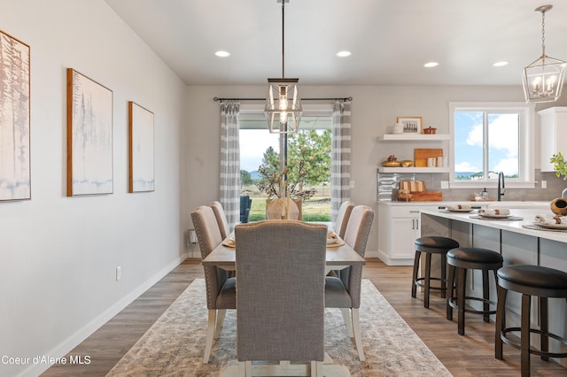 dining room featuring recessed lighting, baseboards, a notable chandelier, and wood finished floors