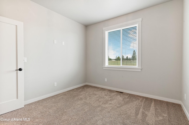 carpeted spare room featuring baseboards