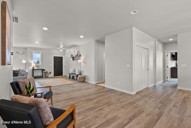 living area with light wood finished floors, visible vents, and recessed lighting