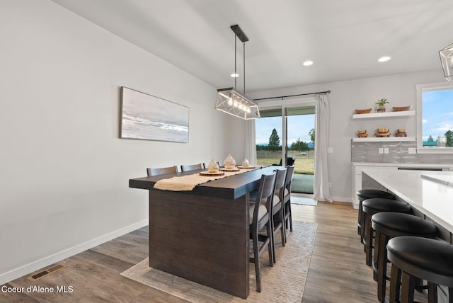 dining area with plenty of natural light, baseboards, and light wood-type flooring