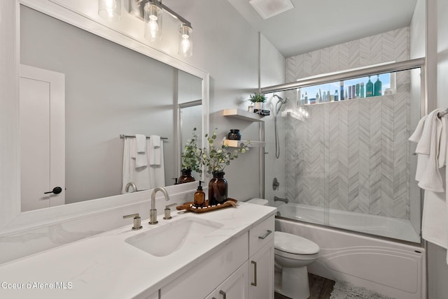bathroom with toilet, shower / bath combination with glass door, and vanity