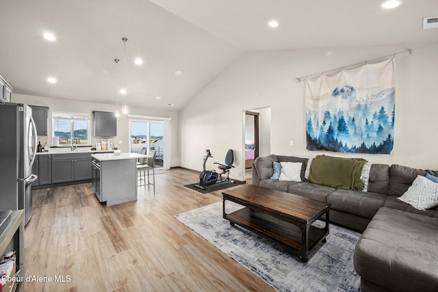 living room featuring light hardwood / wood-style flooring and high vaulted ceiling