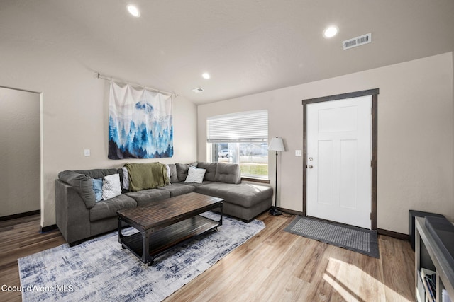 living room with hardwood / wood-style flooring and lofted ceiling