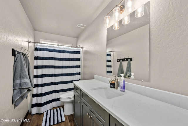 bathroom featuring walk in shower, toilet, a textured ceiling, vanity, and hardwood / wood-style floors