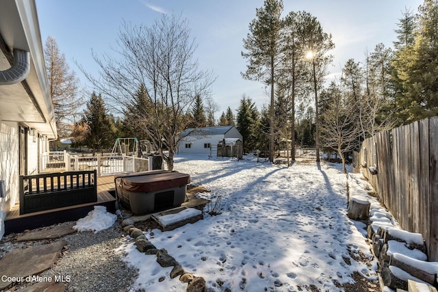 snowy yard featuring a hot tub and an outdoor structure