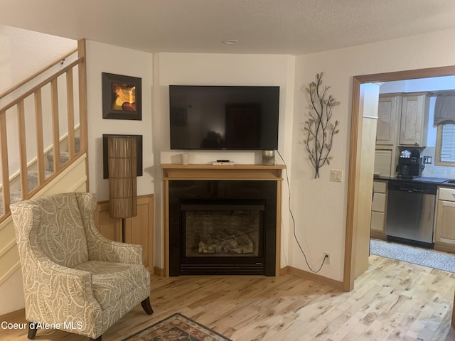 living area with light hardwood / wood-style floors and a textured ceiling