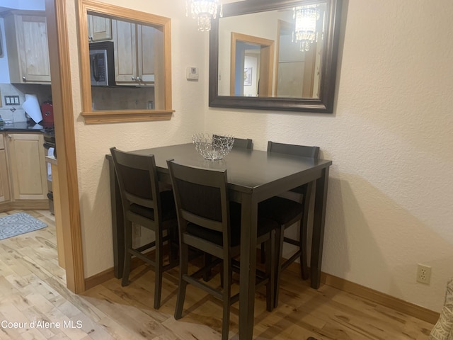 dining space featuring an inviting chandelier and light hardwood / wood-style floors