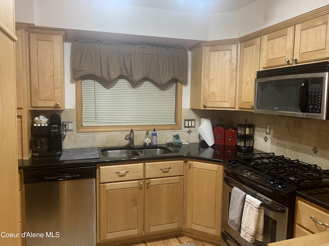 kitchen with light brown cabinetry, sink, backsplash, and stainless steel appliances