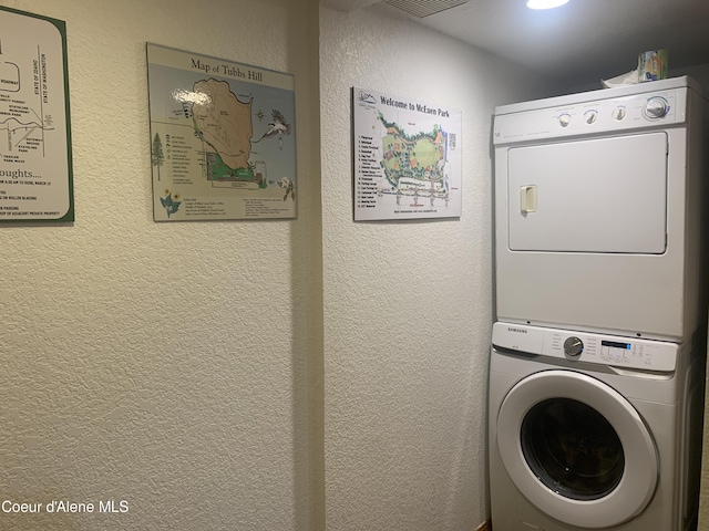 clothes washing area featuring stacked washer and dryer