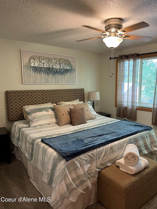 carpeted bedroom with ceiling fan and a textured ceiling