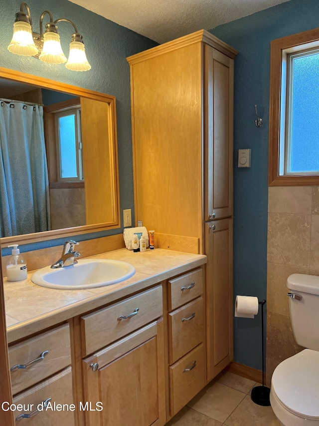 bathroom featuring tile patterned floors, vanity, toilet, and plenty of natural light