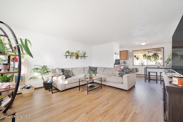 living room with light hardwood / wood-style floors and a textured ceiling