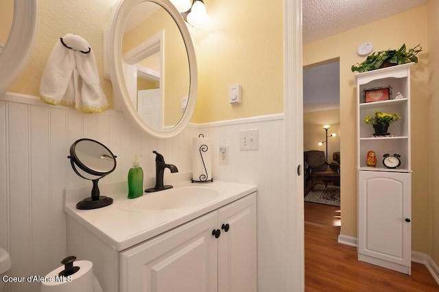 bathroom featuring vanity, hardwood / wood-style floors, and a textured ceiling