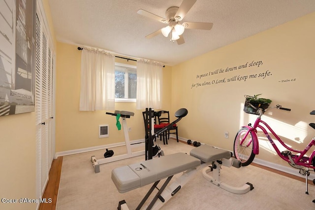 workout room featuring ceiling fan and a textured ceiling