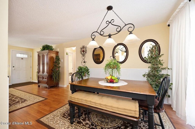 dining space featuring hardwood / wood-style flooring and a textured ceiling