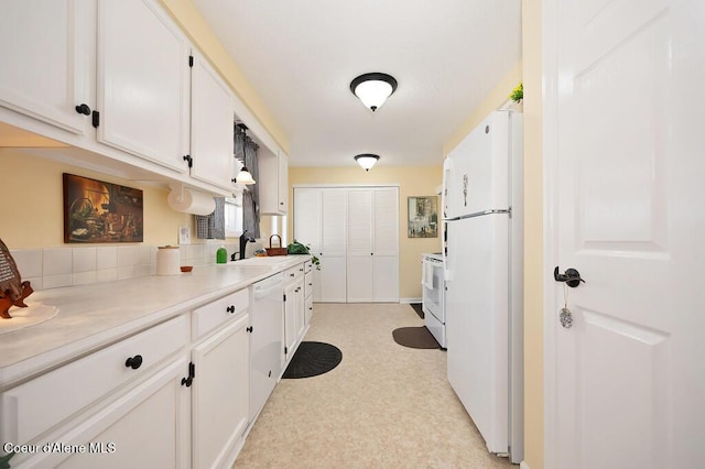 kitchen featuring white cabinetry, sink, and white appliances