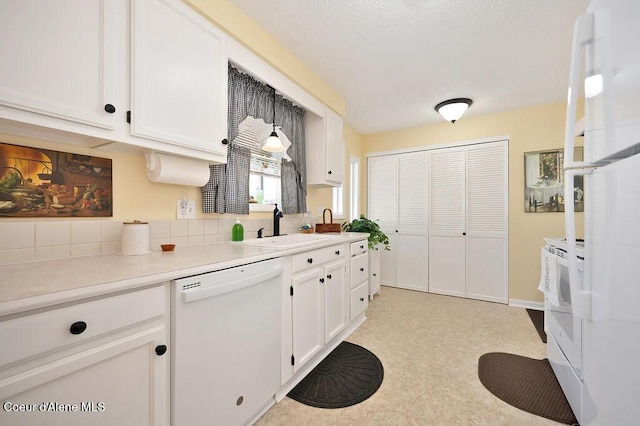 kitchen featuring dishwasher, sink, and white cabinets