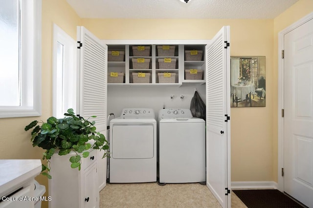 washroom featuring washer and clothes dryer and a textured ceiling