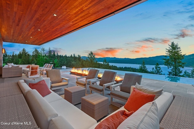 patio terrace at dusk with an outdoor living space and a mountain view