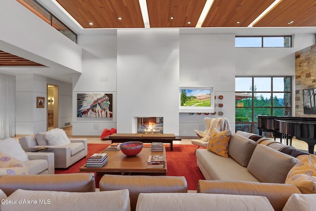 living room featuring a high ceiling, a large fireplace, and wood ceiling