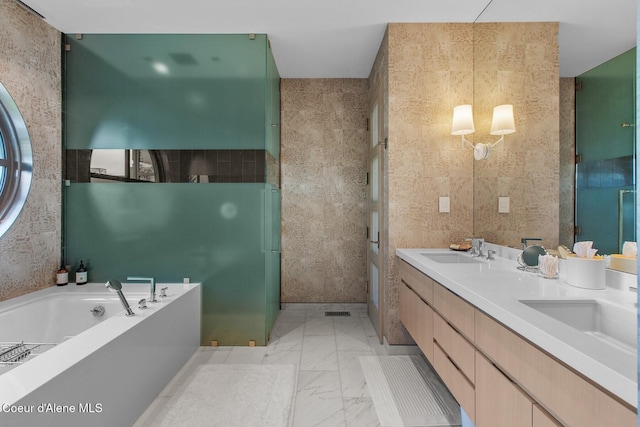 bathroom with vanity, a tub, and tile walls