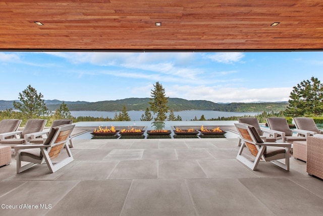 view of patio with a fire pit and a water and mountain view