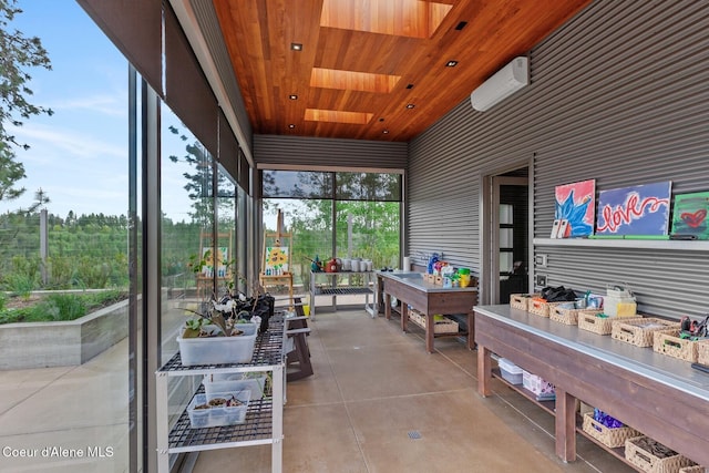 sunroom / solarium featuring a wall mounted air conditioner, a skylight, and wooden ceiling