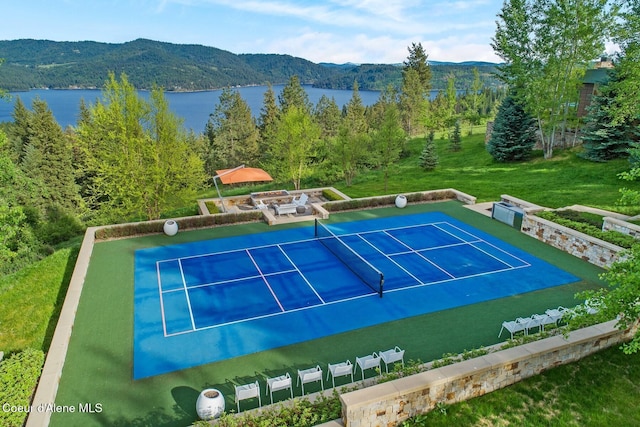 view of sport court featuring a water and mountain view