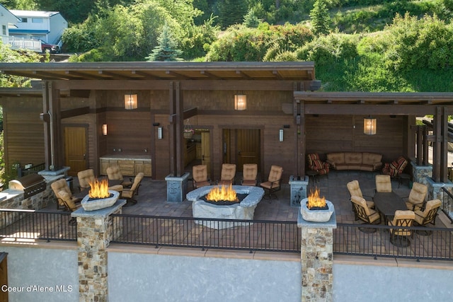 wooden deck featuring a patio, a grill, and a fire pit