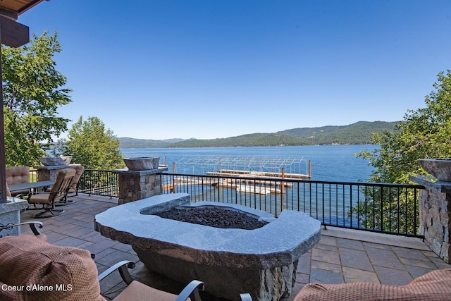 view of patio with a fire pit and a water and mountain view