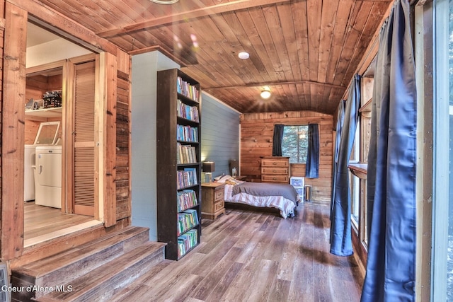 unfurnished bedroom with hardwood / wood-style floors, washer and clothes dryer, wooden ceiling, and wood walls