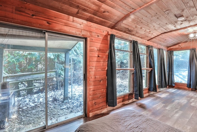 interior space featuring hardwood / wood-style flooring, wood walls, vaulted ceiling, and wooden ceiling