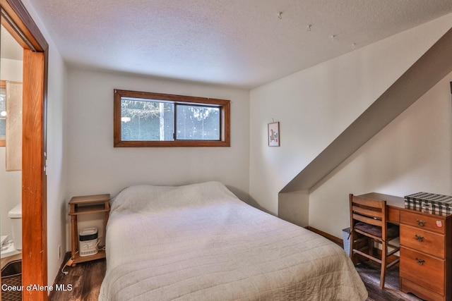 bedroom featuring dark hardwood / wood-style floors and a textured ceiling