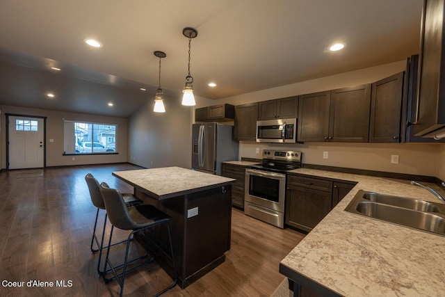 kitchen featuring sink, a kitchen breakfast bar, a kitchen island, pendant lighting, and stainless steel appliances