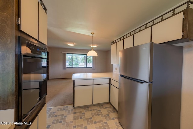 kitchen featuring black double oven, white cabinetry, stainless steel fridge, and decorative light fixtures