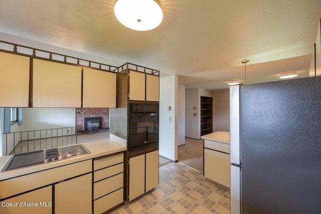 kitchen with decorative light fixtures, a brick fireplace, and black appliances