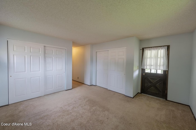 unfurnished bedroom featuring light carpet and a textured ceiling