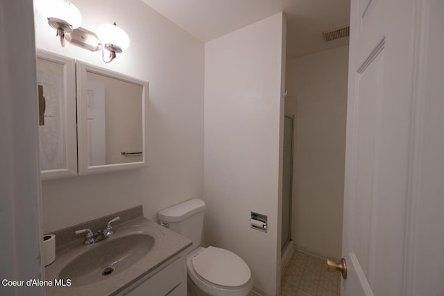 bathroom featuring vanity, toilet, and an enclosed shower