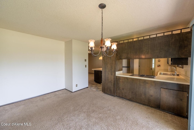 kitchen featuring sink, a textured ceiling, stainless steel fridge, pendant lighting, and light colored carpet