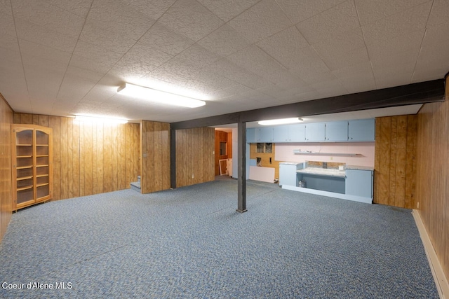 basement featuring carpet flooring and wood walls