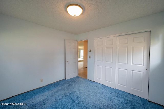 unfurnished bedroom featuring a closet, carpet, and a textured ceiling