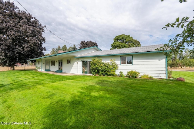 rear view of house featuring a yard and a patio