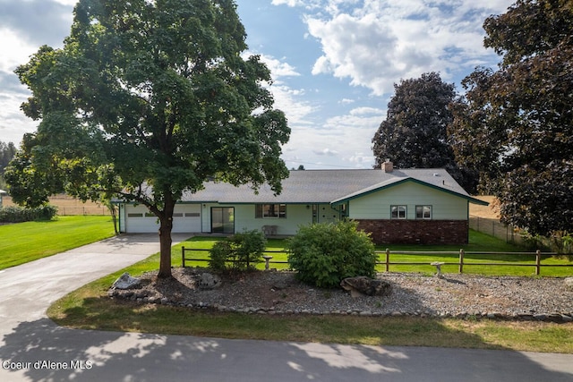 single story home featuring a garage and a front lawn