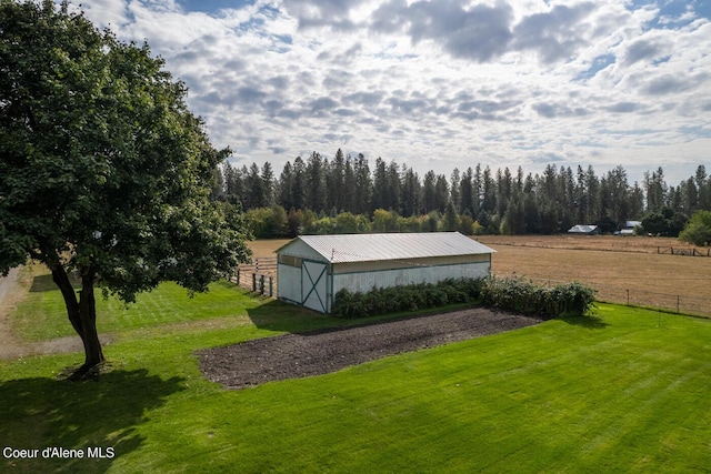 view of outdoor structure with a rural view and a lawn